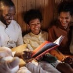 A joyful family enjoys a cozy bedtime story together in a warm home setting.