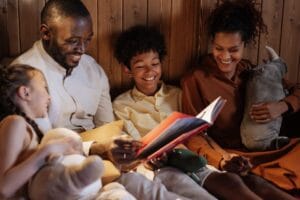 A joyful family enjoys a cozy bedtime story together in a warm home setting.