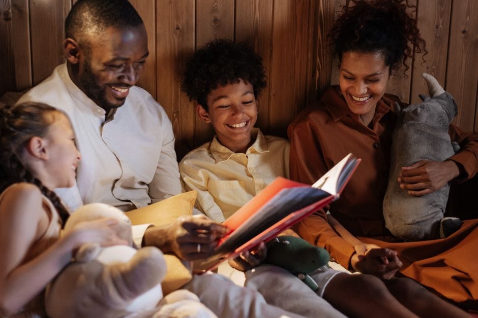 A joyful family enjoys a cozy bedtime story together in a warm home setting.